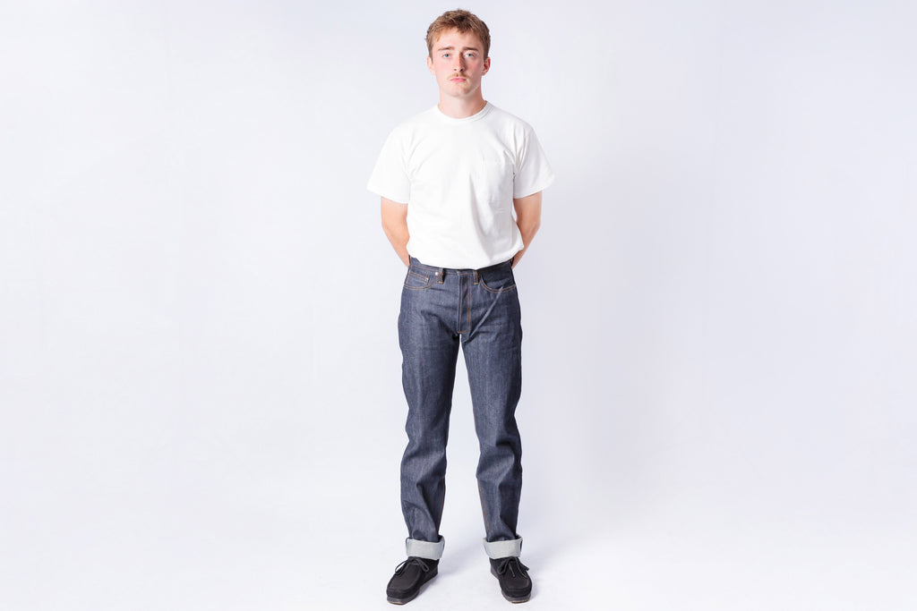 Person wearing a white t-shirt and blue jeans on a white background
