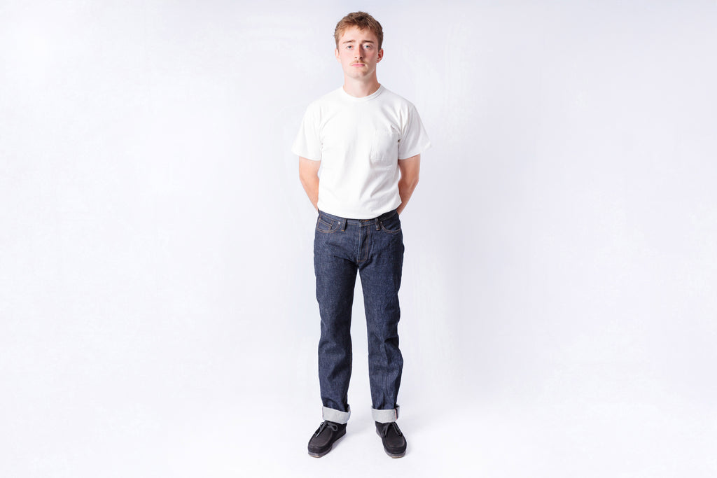 Person wearing a white t-shirt and blue jeans on a white background