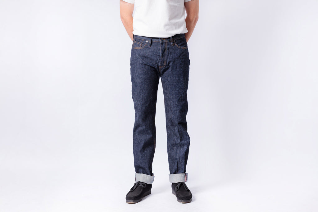 Person wearing dark blue jeans and a white shirt on a white background
