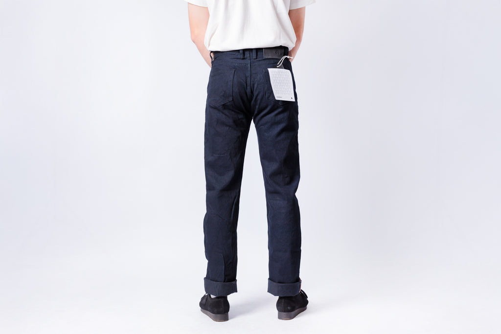 Person wearing dark blue pants on a white background