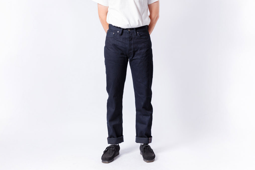 Person wearing dark blue jeans and a white shirt on a white background