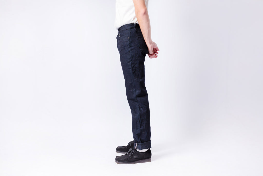 Person wearing dark blue jeans on a white background