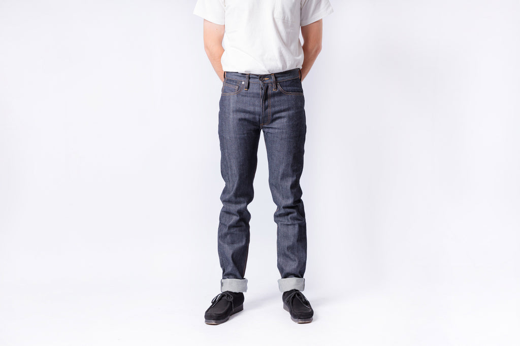 Person wearing dark blue jeans and a white shirt on a white background