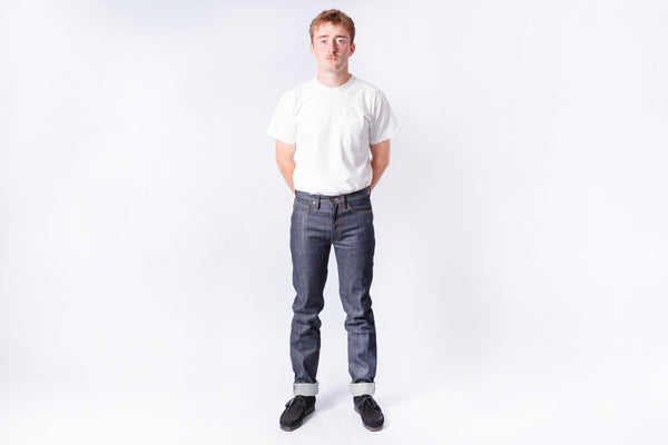 Person wearing a white t-shirt and dark jeans on a white background