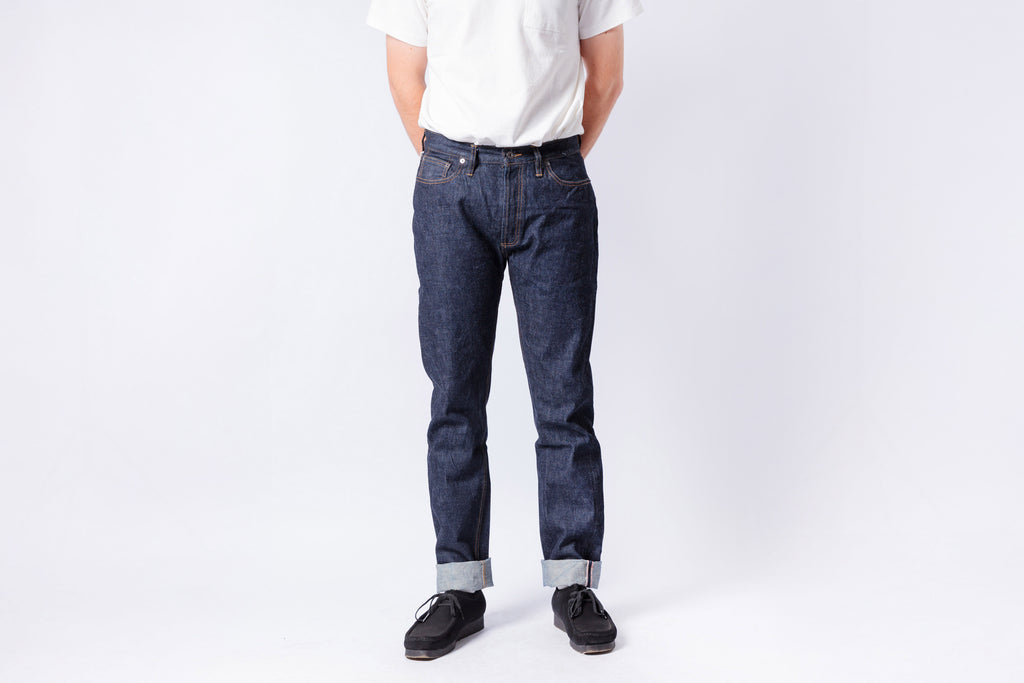 Person wearing dark blue jeans and a white shirt on a white background