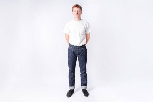 Person wearing a white t-shirt and blue jeans on a white background