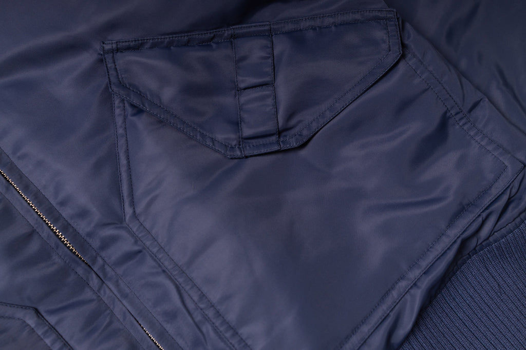 Close-up of a navy blue jacket with a zipper and pocket