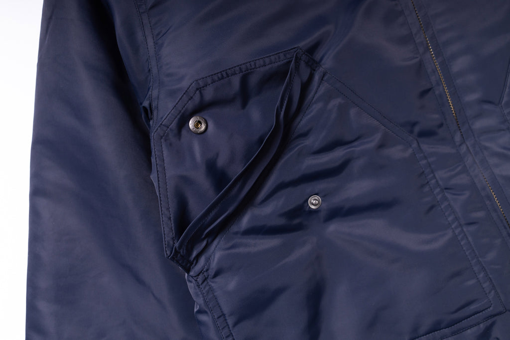 Close-up of a navy blue jacket with button details on a white background