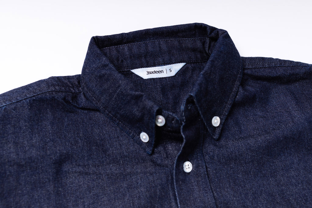Navy blue shirt with collar and buttons on a white background