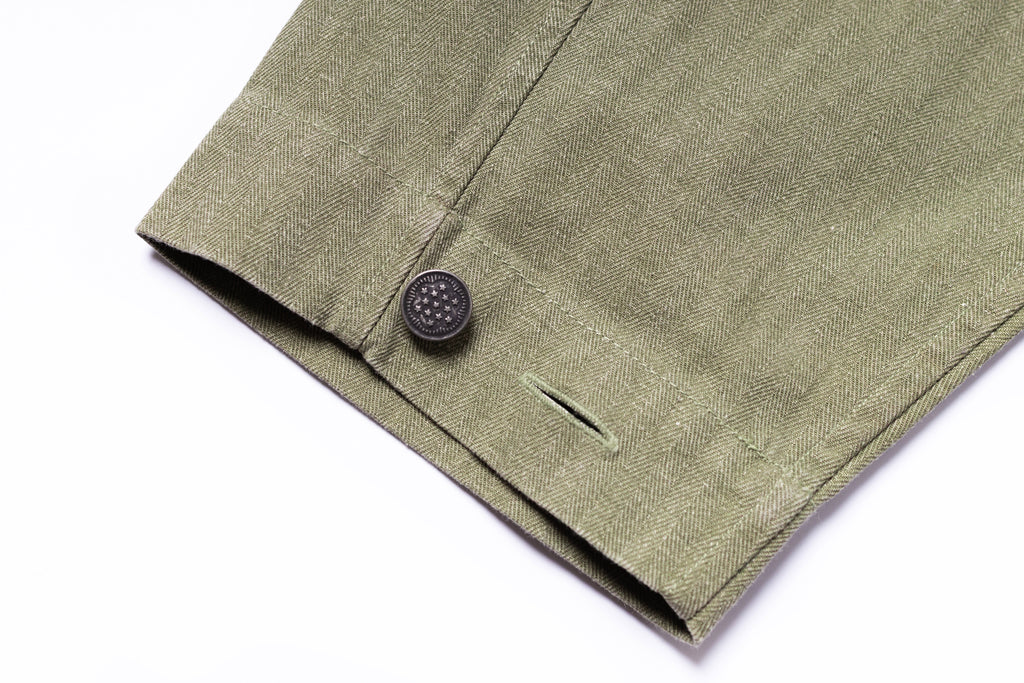 Close-up of a green fabric with a button on a white background