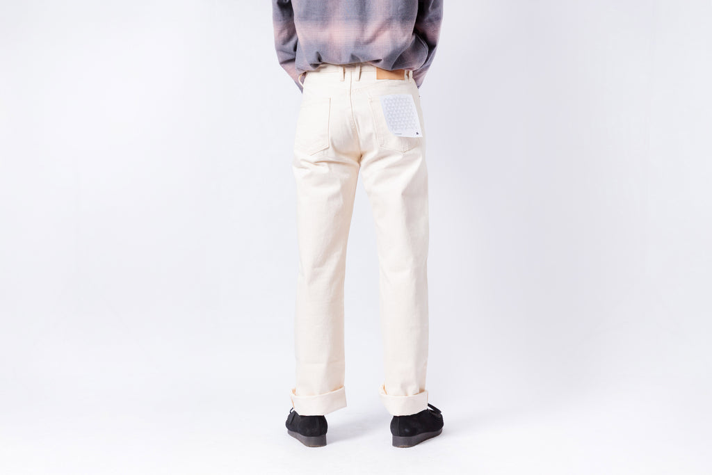 Person wearing light-colored pants and a gray top on a white background