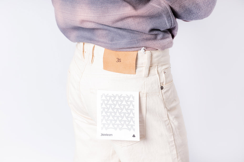 Person wearing a light purple sweater and beige pants on a white background