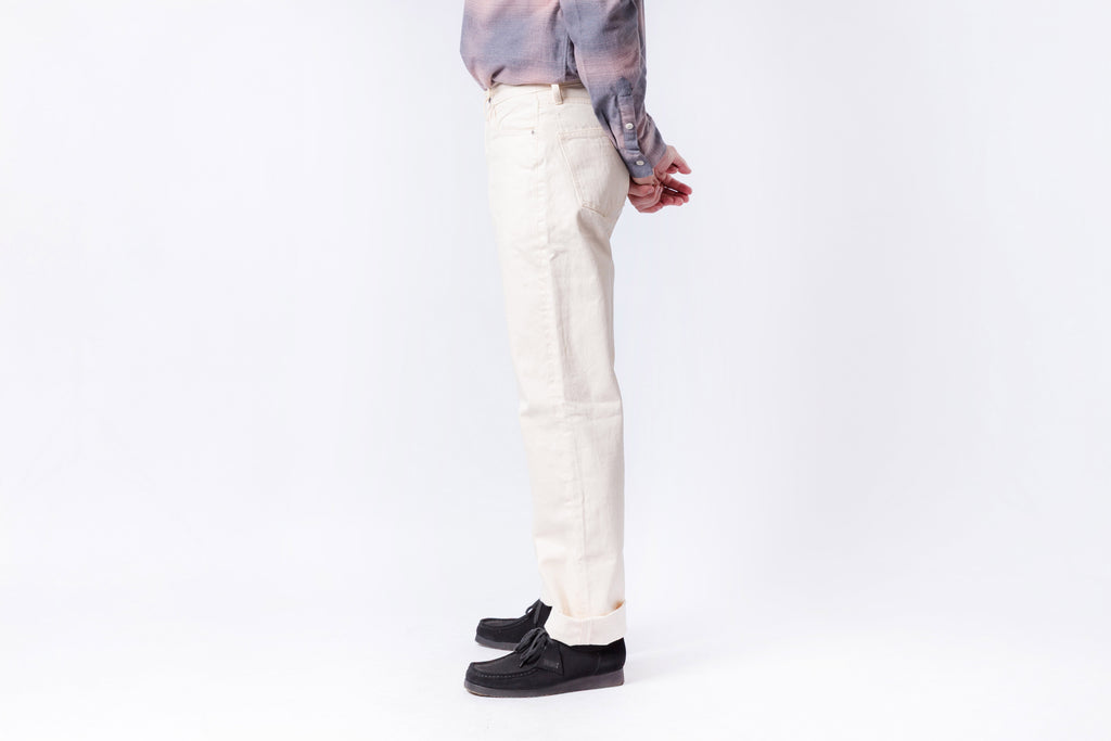 Person wearing white pants and black shoes on a white background