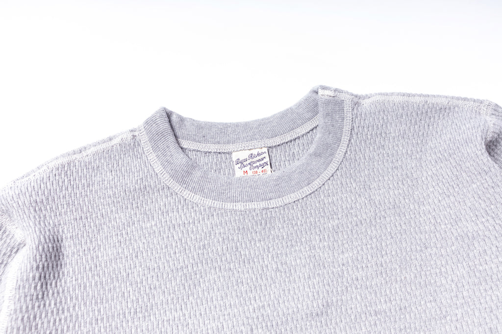 Gray textured sweater with a brand label on a white background