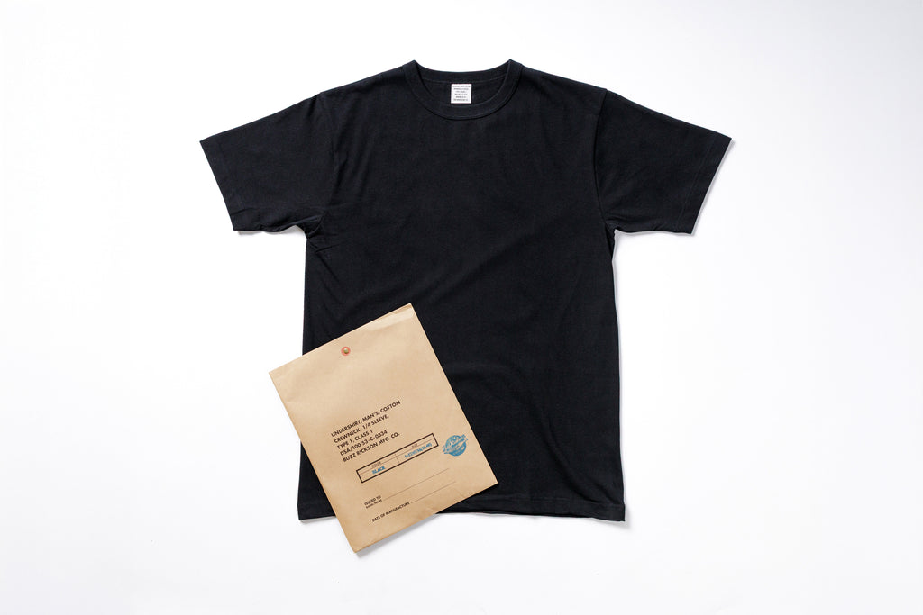 Black t-shirt and brown envelope on a white background