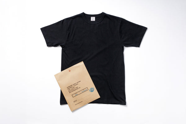 Black t-shirt and brown envelope on a white background