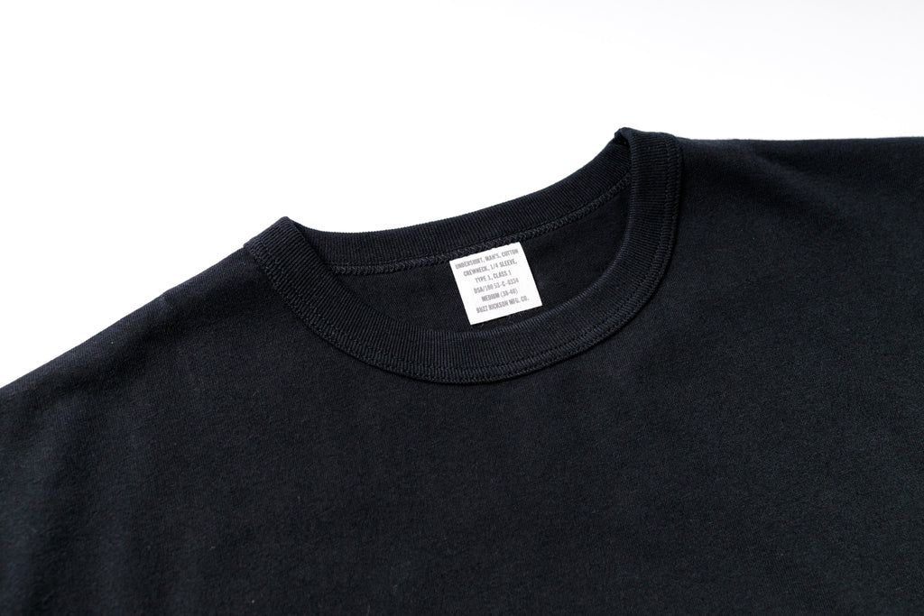 Black t-shirt with a label on a white background