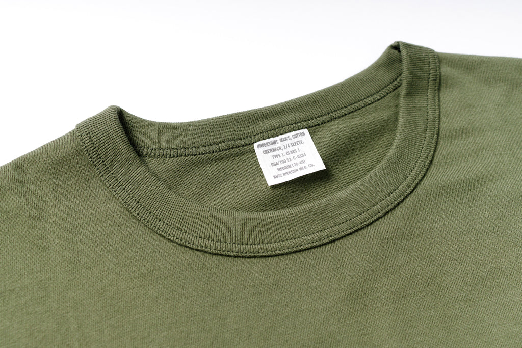 Close-up of a green shirt with a label on a white background