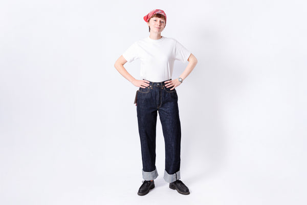 Person wearing a white t-shirt, dark jeans, and a red bandana on a white background