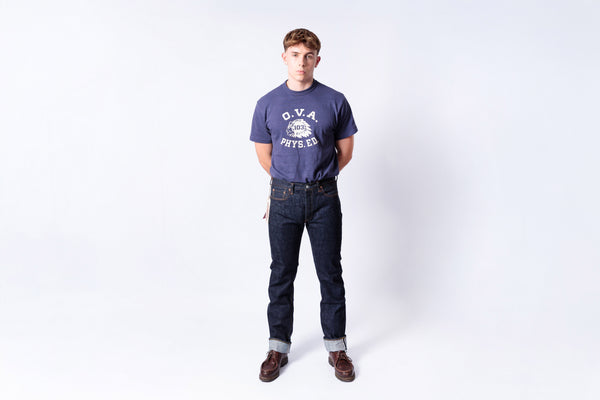 Man wearing a navy blue t-shirt and jeans on a white background