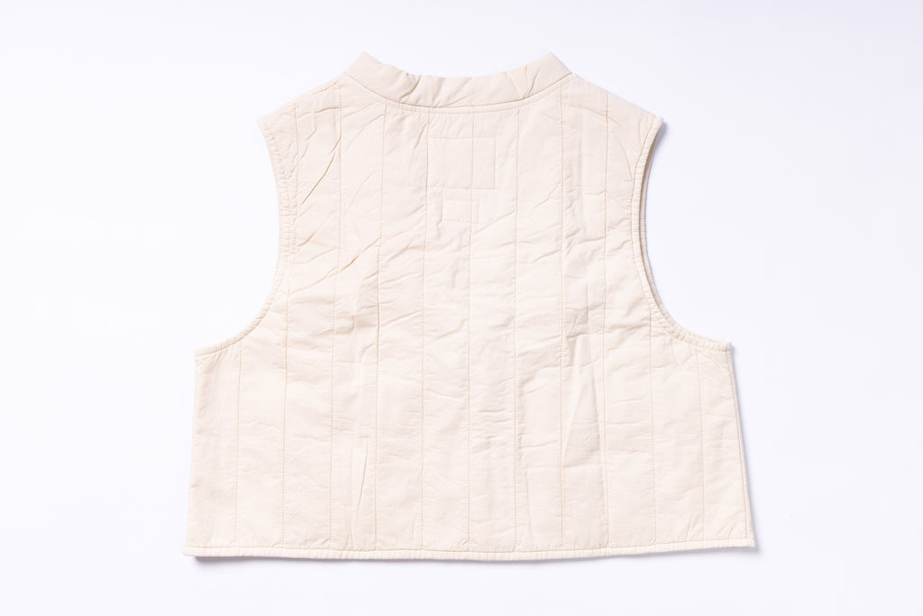 Beige quilted vest on a light gray background