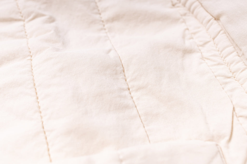 Close-up of a beige quilted fabric texture