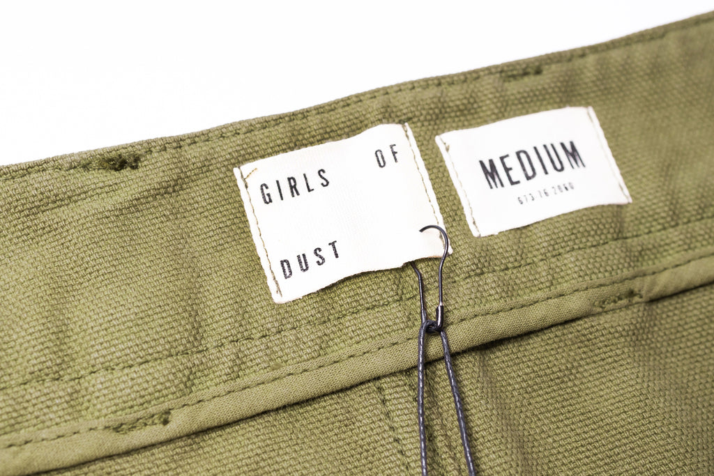 Green fabric with 'Girls of Dust' label and 'Medium' tag on a white background