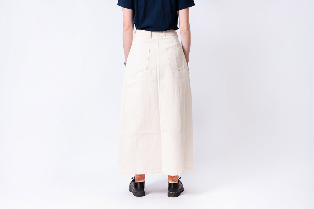 Person wearing a navy shirt and beige wide-leg pants on a white background