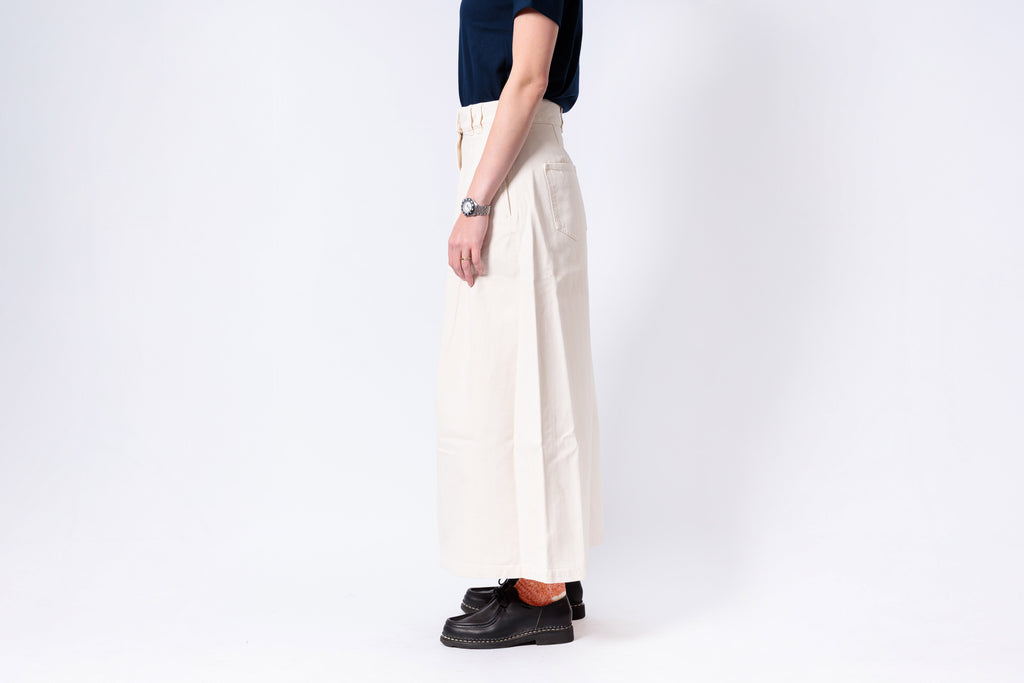 Person wearing white pants and black shoes on a white background