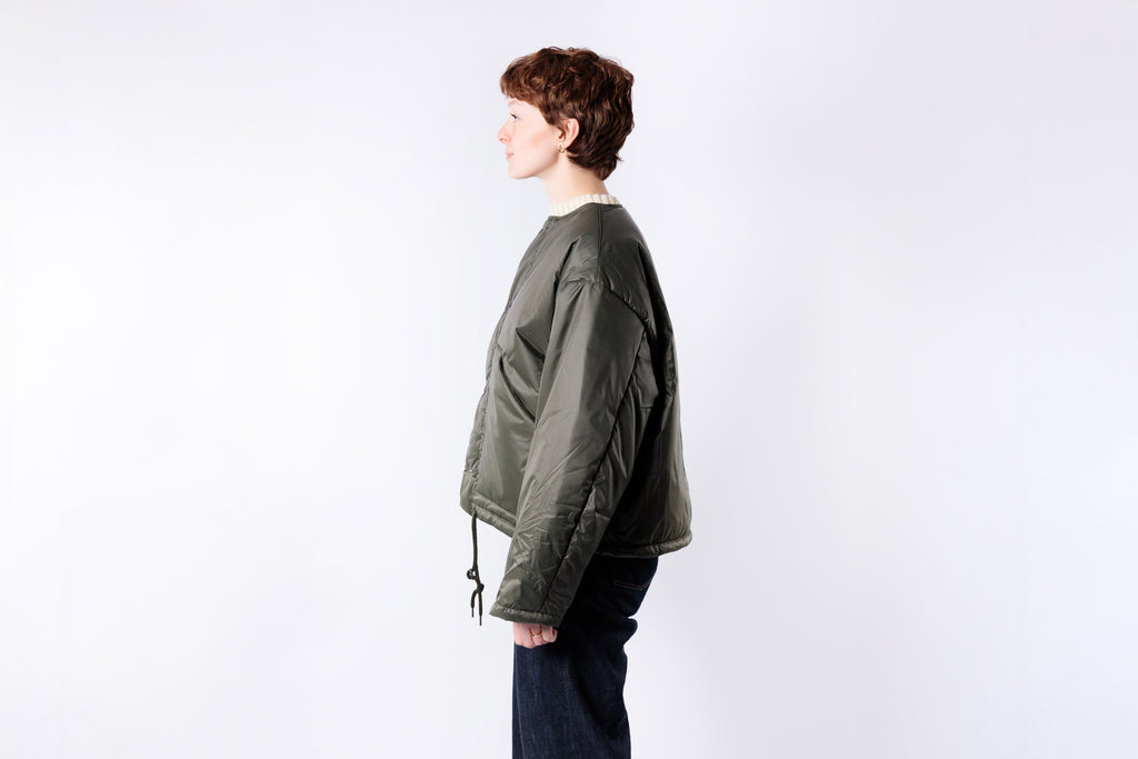 Person wearing a green jacket on a white background