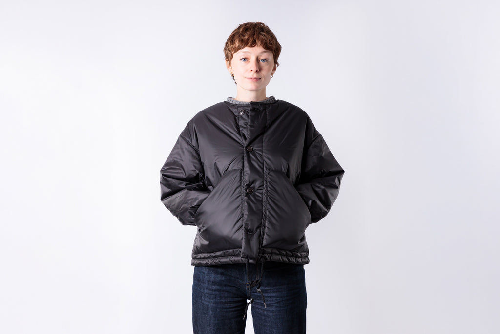 Person wearing a black puffer jacket on a white background