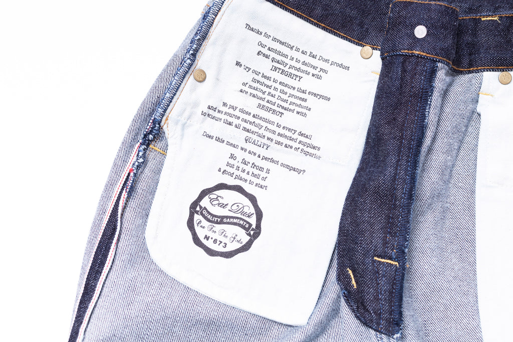Close-up of a denim garment with a label and brand logo.