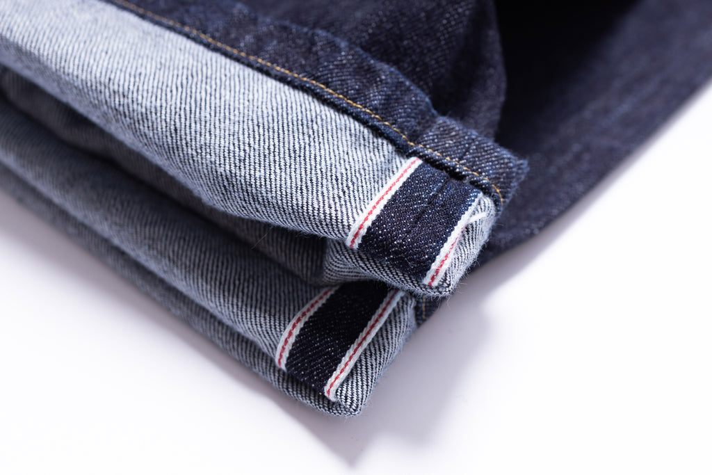 Folded denim jeans on a white background