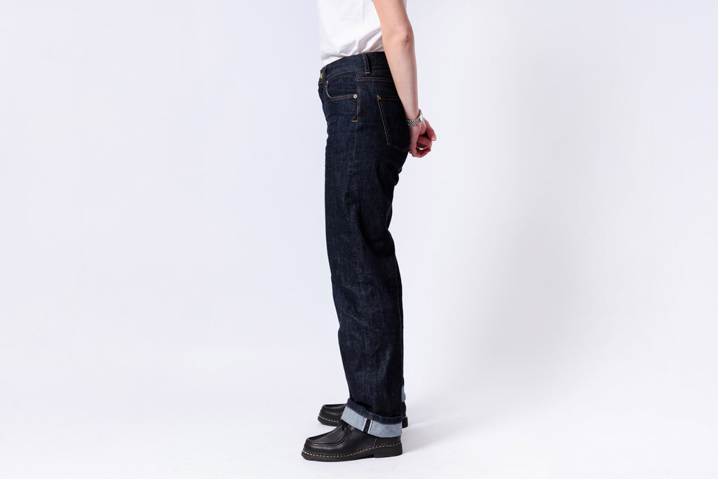 Person wearing dark blue jeans on a white background