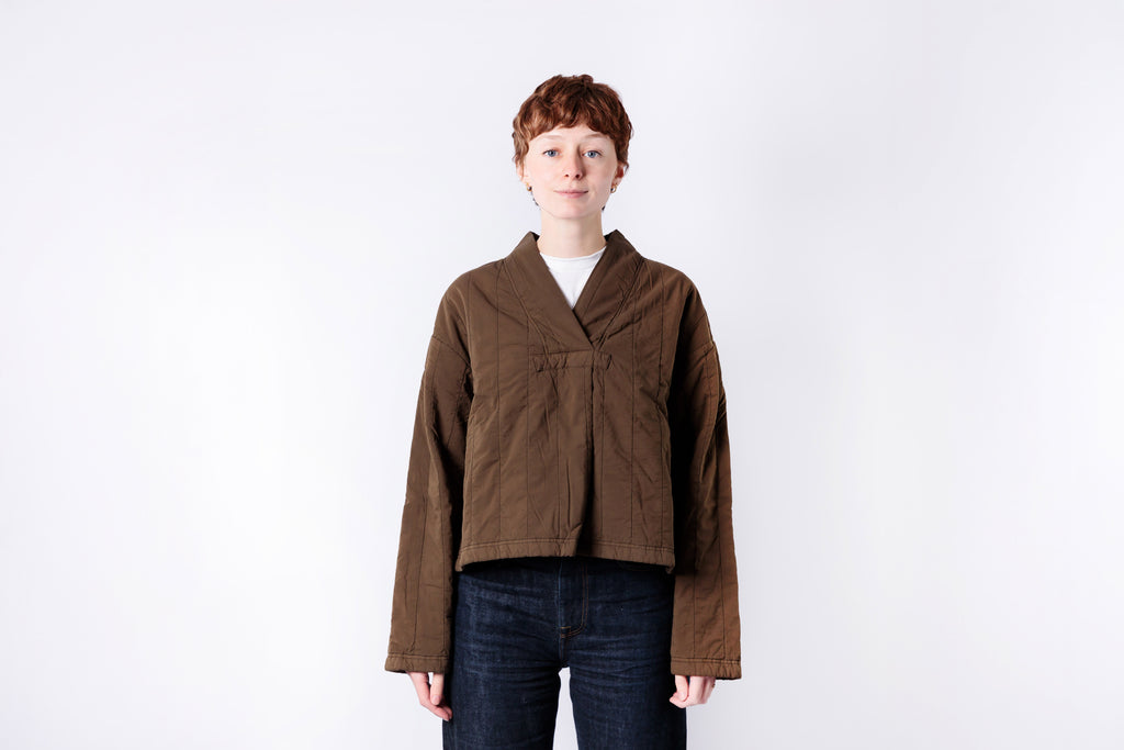 Person wearing a brown jacket on a white background