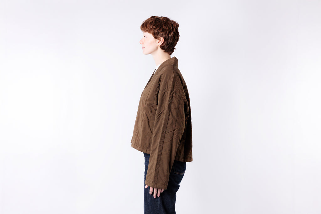 Person wearing a brown jacket on a white background