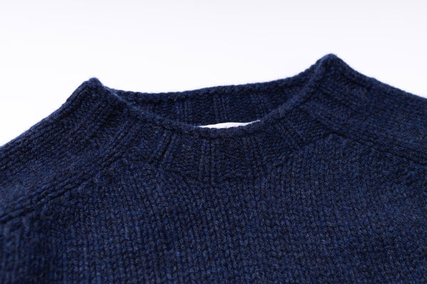 Close-up of a navy blue sweater collar on a white background