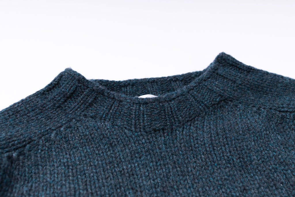 Close-up of a blue knitted sweater collar on a white background