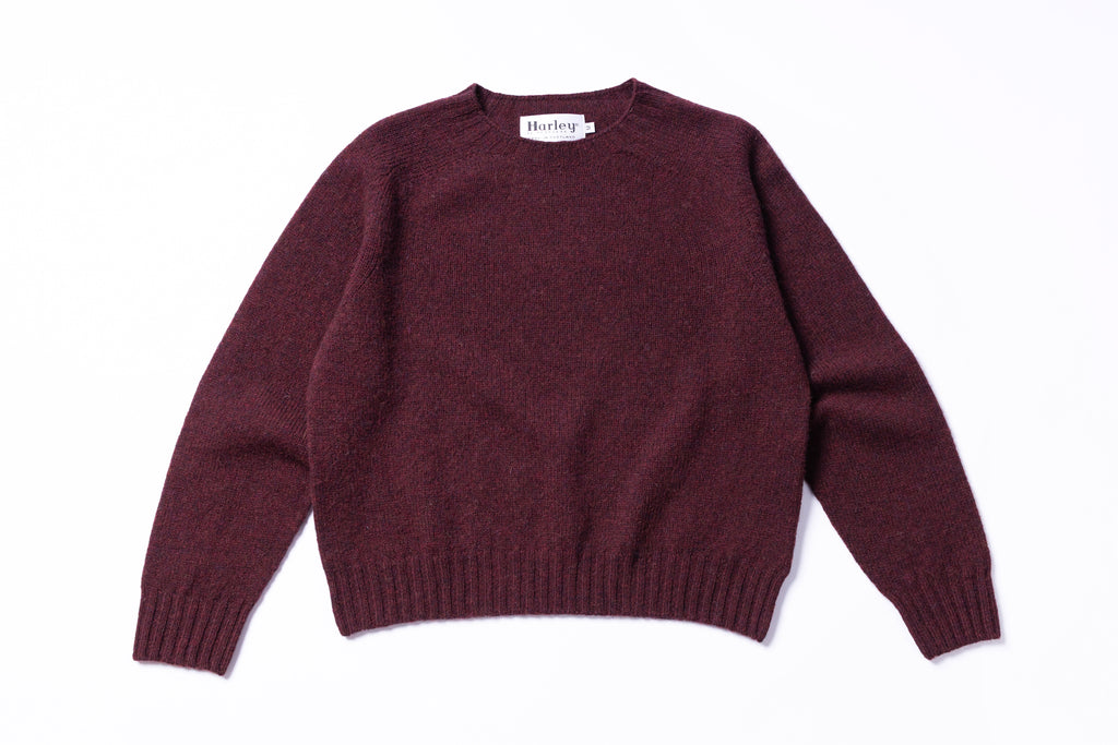 Maroon sweater with a brand label on a white background