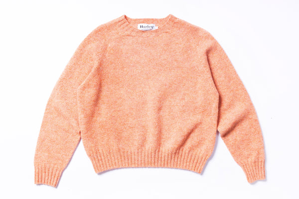 Peach-colored sweater on a white background