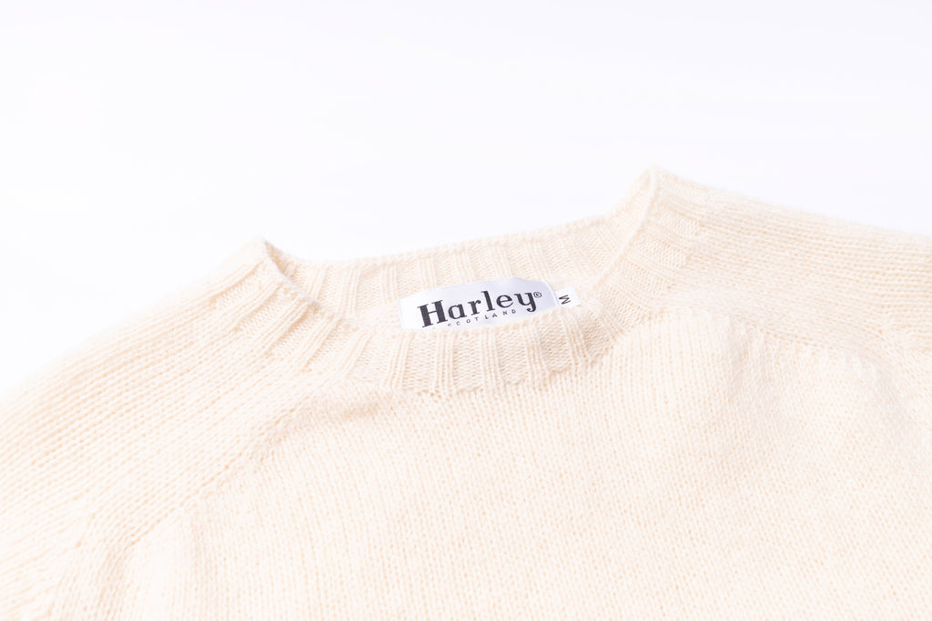 Beige sweater with 'Harley' logo on a white background