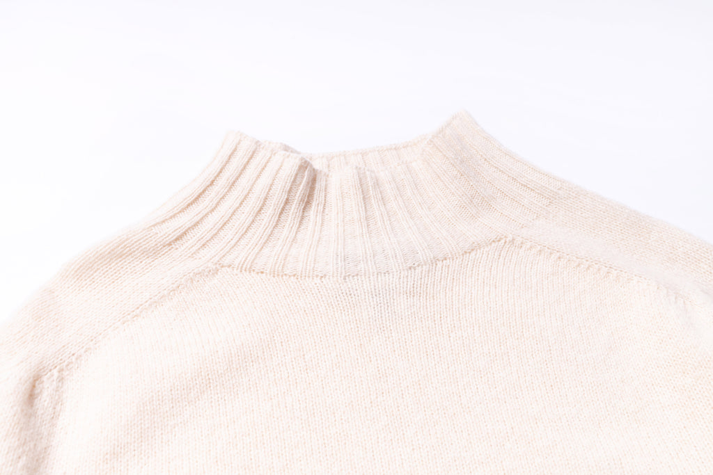 Close-up of a beige sweater collar on a white background