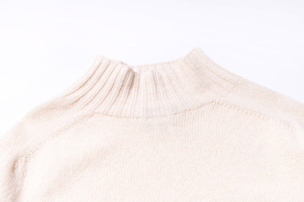 Close-up of a beige sweater collar on a white background