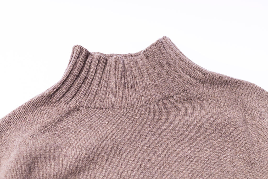 Close-up of a brown knitted sweater on a white background