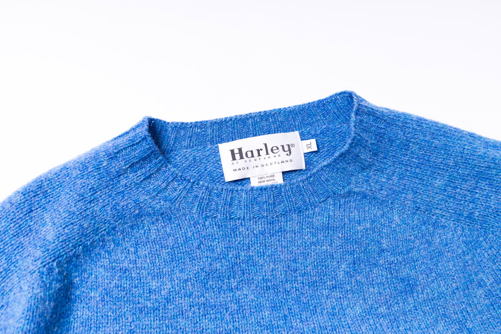 Blue sweater with a Harley label on a white background