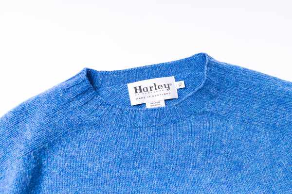 Blue sweater with a Harley label on a white background