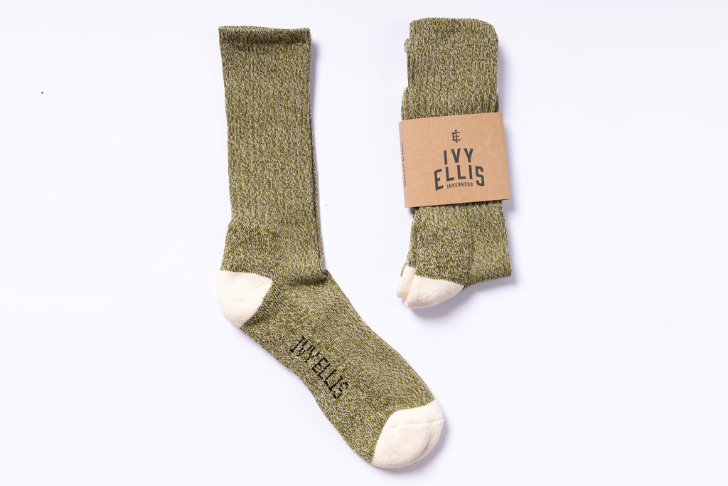 Pair of green socks with a visible brand label on a white background
