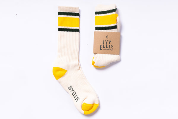 Pair of socks with yellow accents and 'Ivy Ellis' branding on a white background
