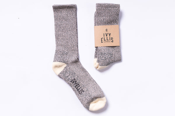 Pair of gray socks with a visible brand label on a white background