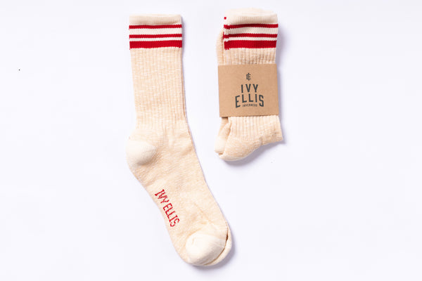 Pair of cream socks with red stripes and 'Ivy Ellis' branding on a white background